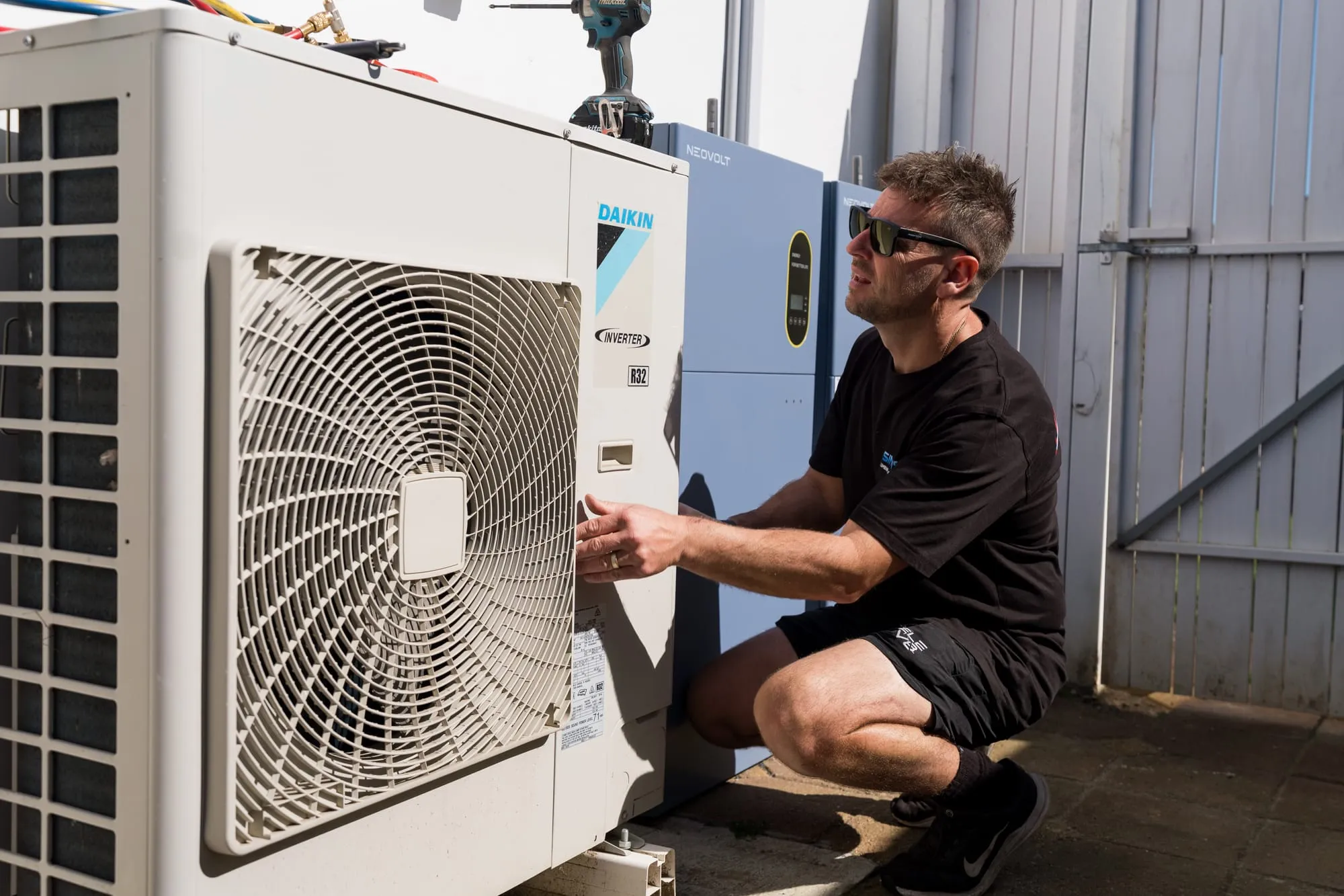 Simms technician checking an air conditioner condenser