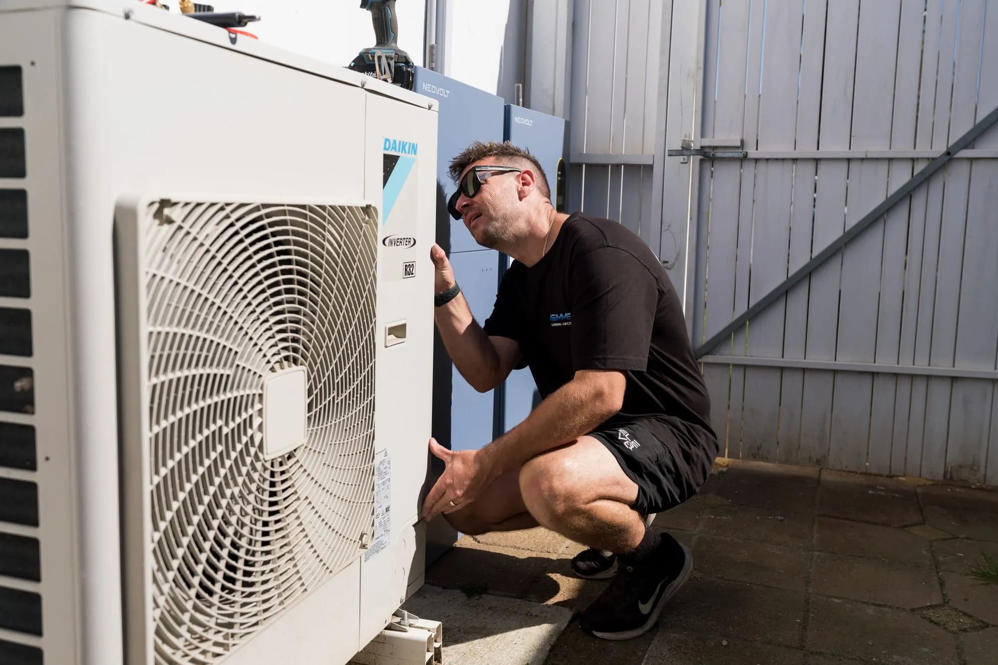 Simms technician working on a Daikin condenser