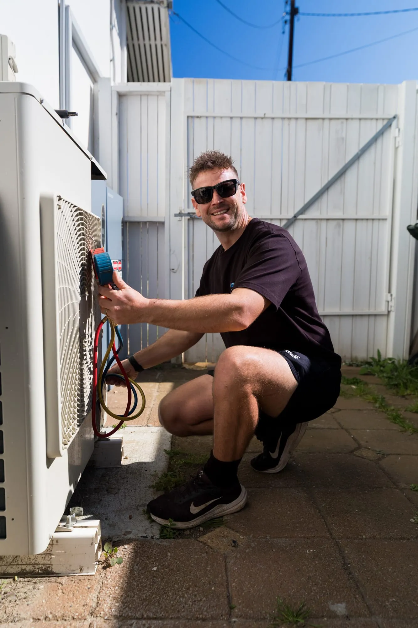 Simms technician servicing a split system outdoor unit