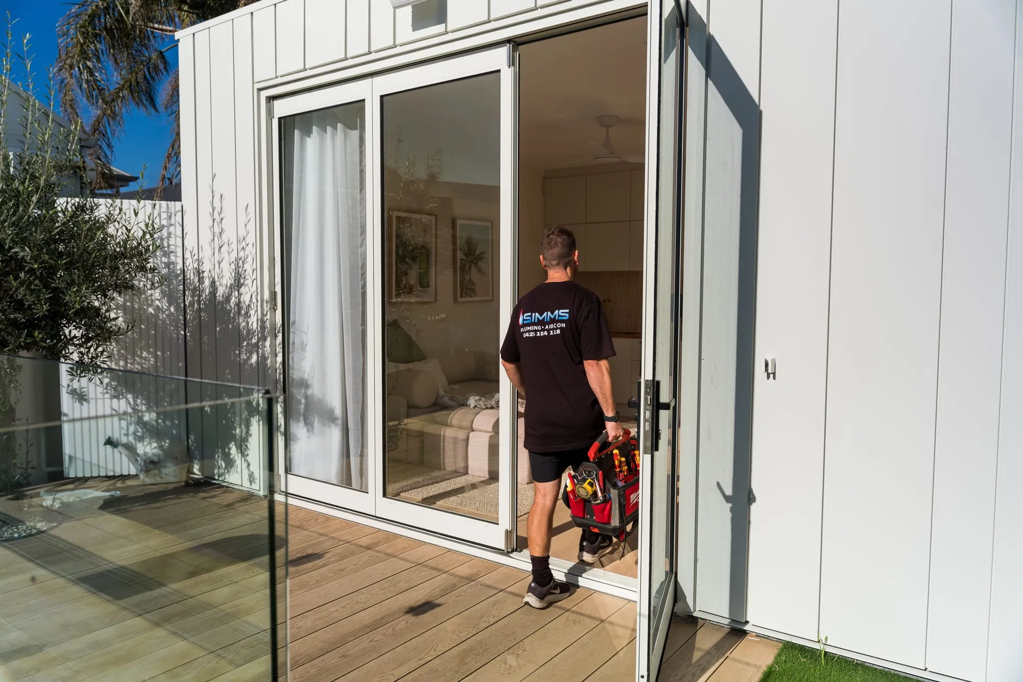 Simms plumber arriving at a home with his toolbag