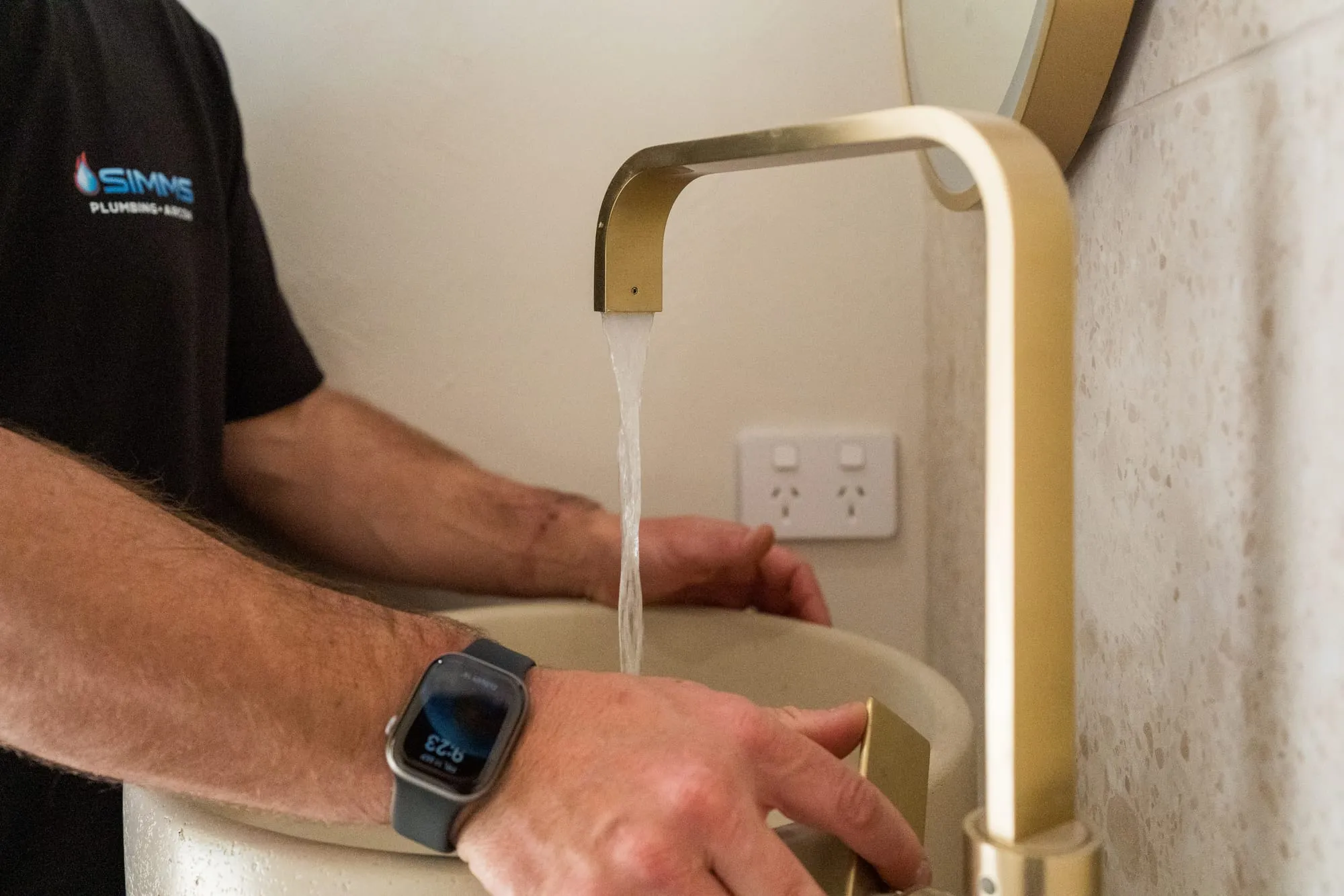 Bathroom basin mixer running water into a vessel basin