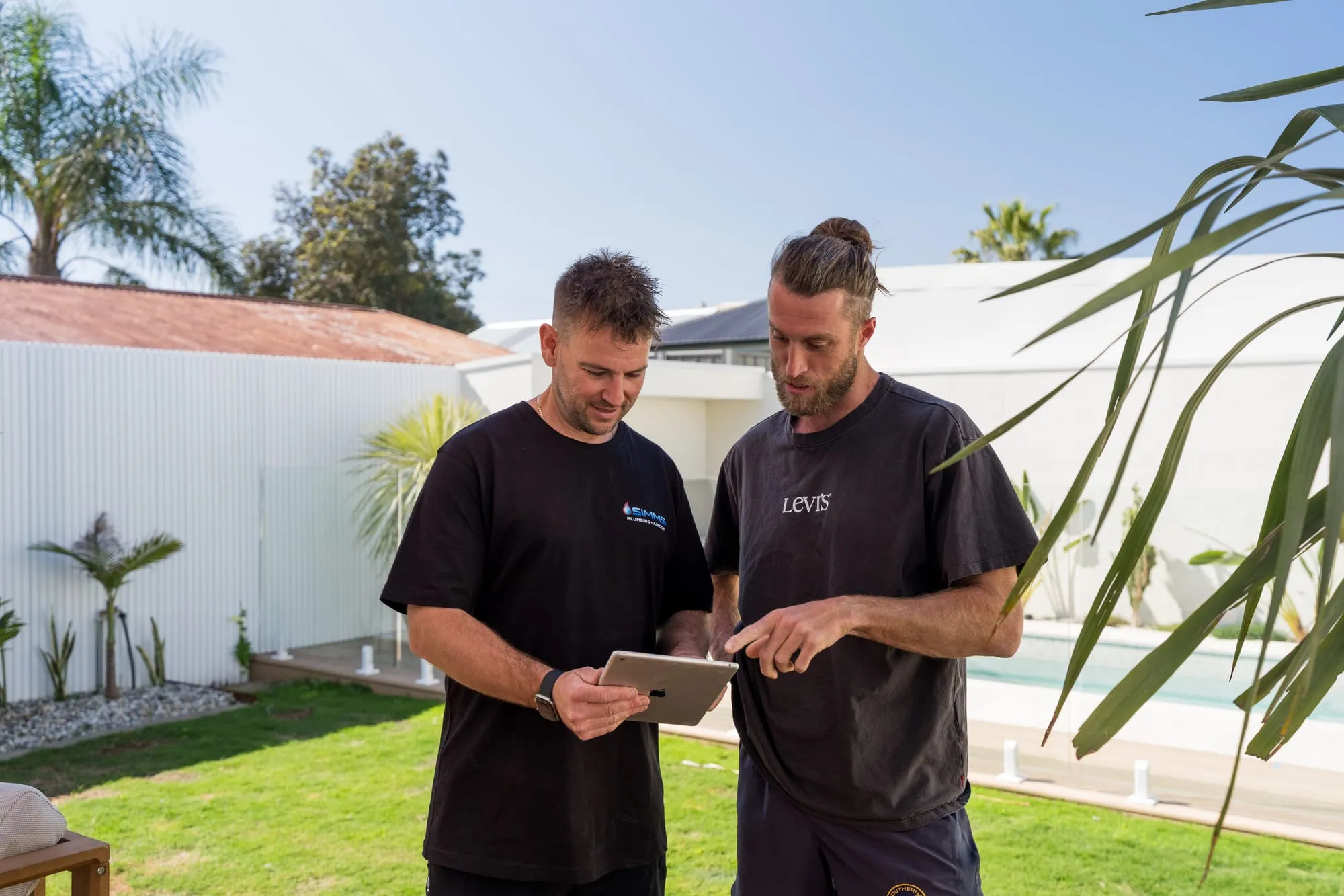 Talking through a quote on a tablet in a backyard