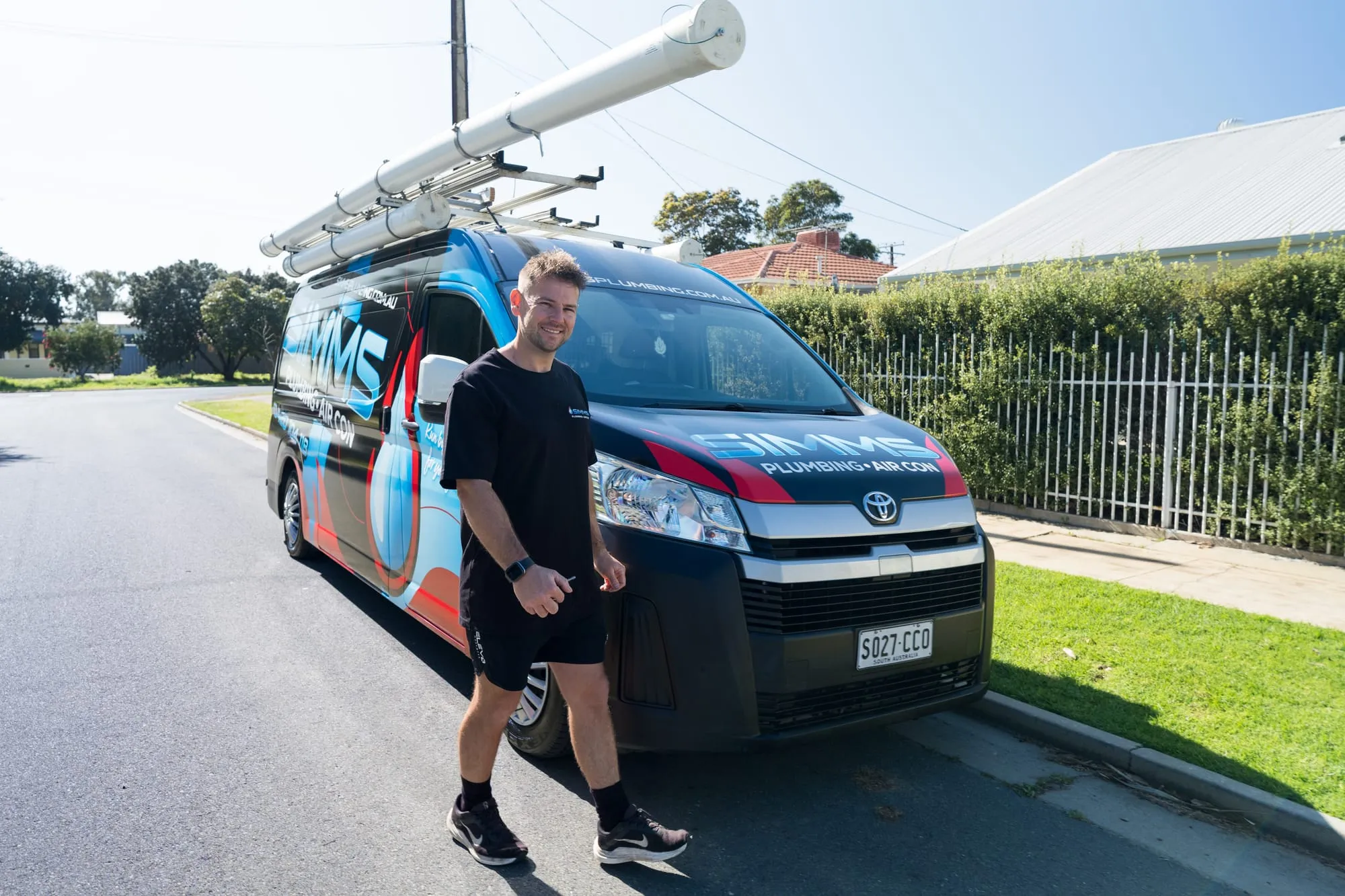 Simms plumber in front of the Simms Plumbing and Air Con van