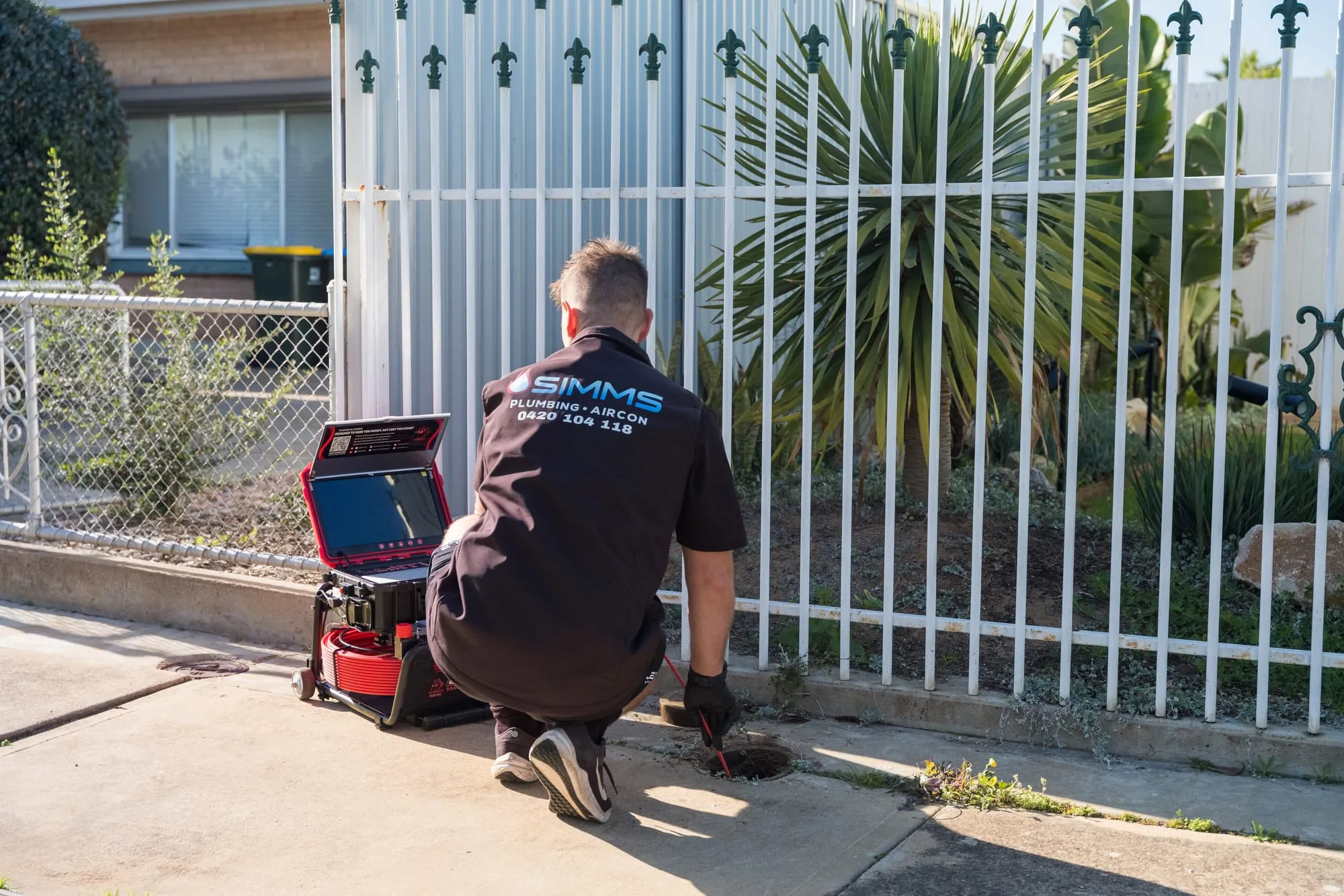 Simms plumber using high-pressure drain jetting equipment