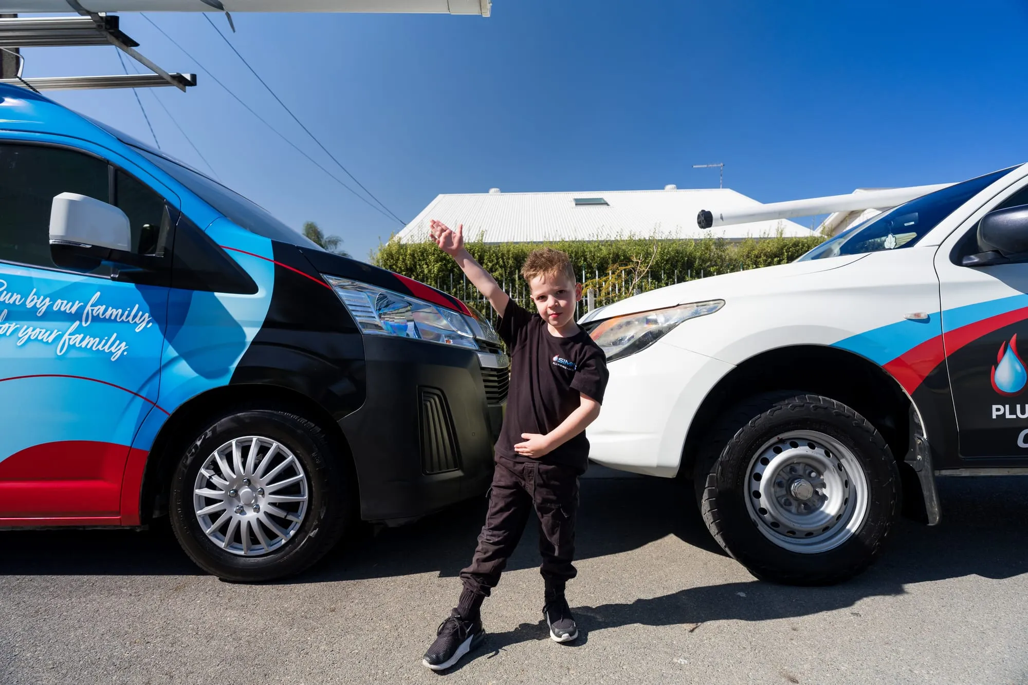 A young member of the Simms family waving in front of the vans