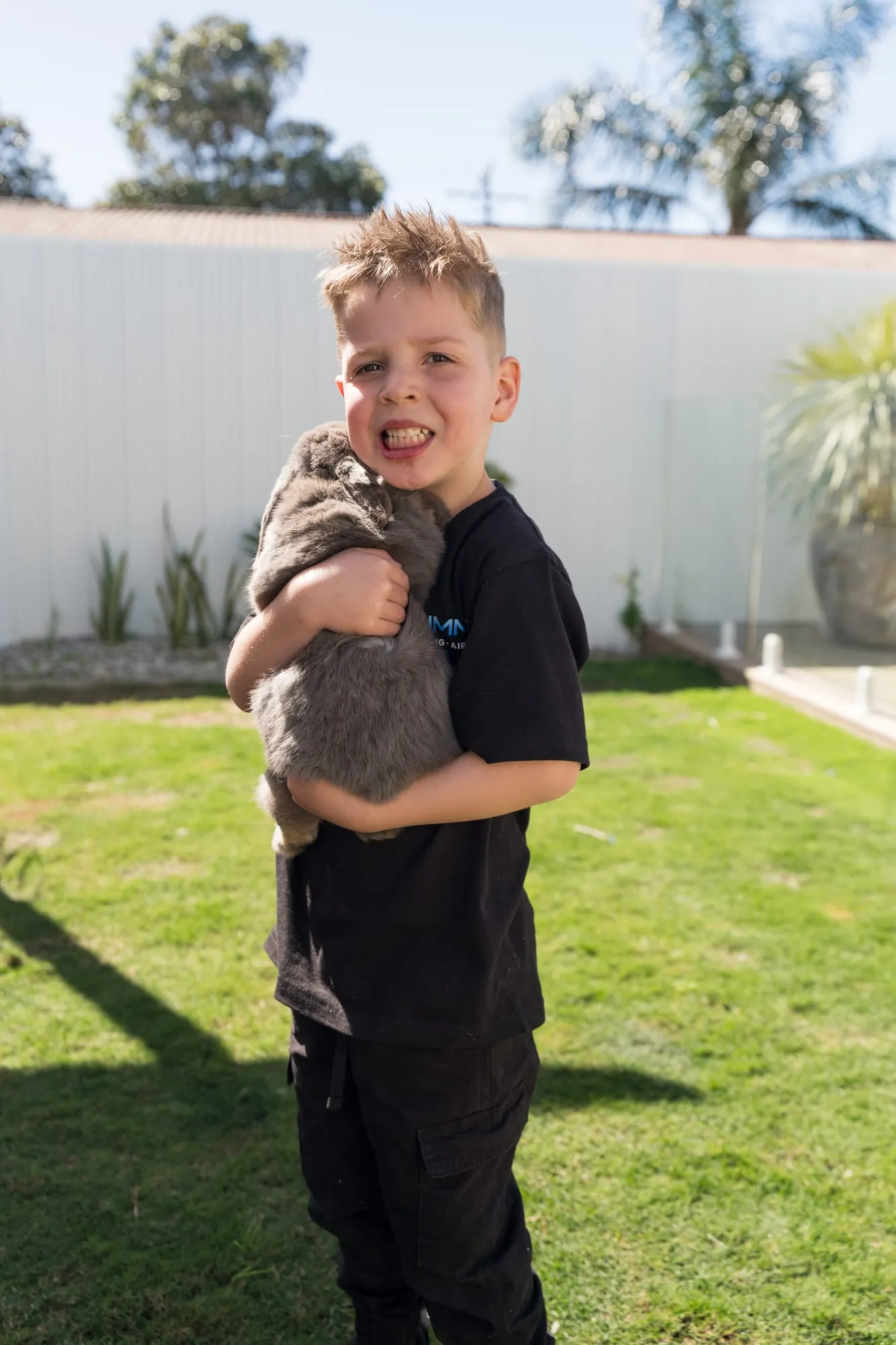 A young member of the Simms family holding the family cat