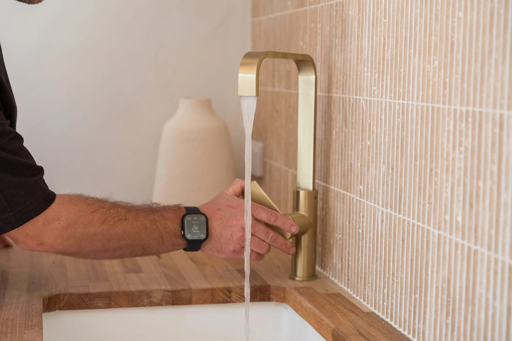 Brushed brass kitchen mixer tap running after a repair