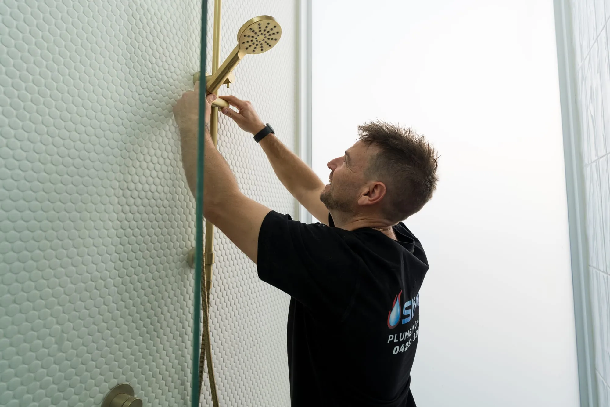 Simms plumber checking a shower head